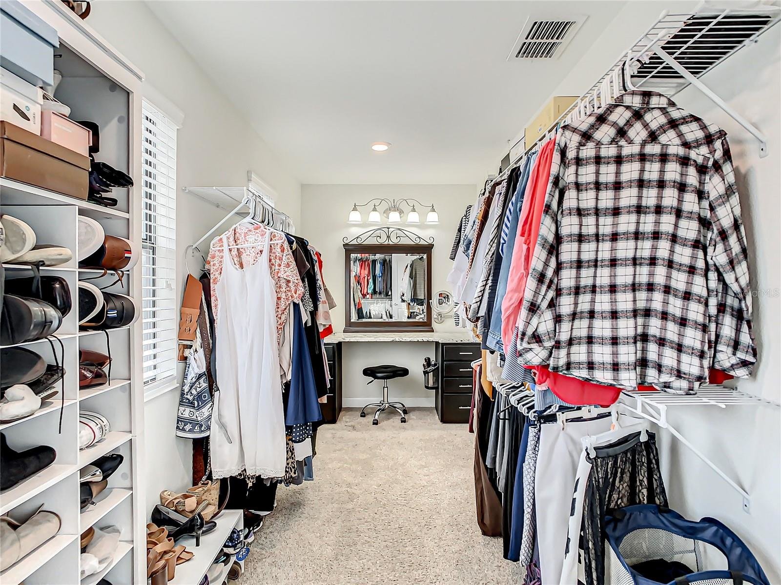 walk in closet with vanity in the back